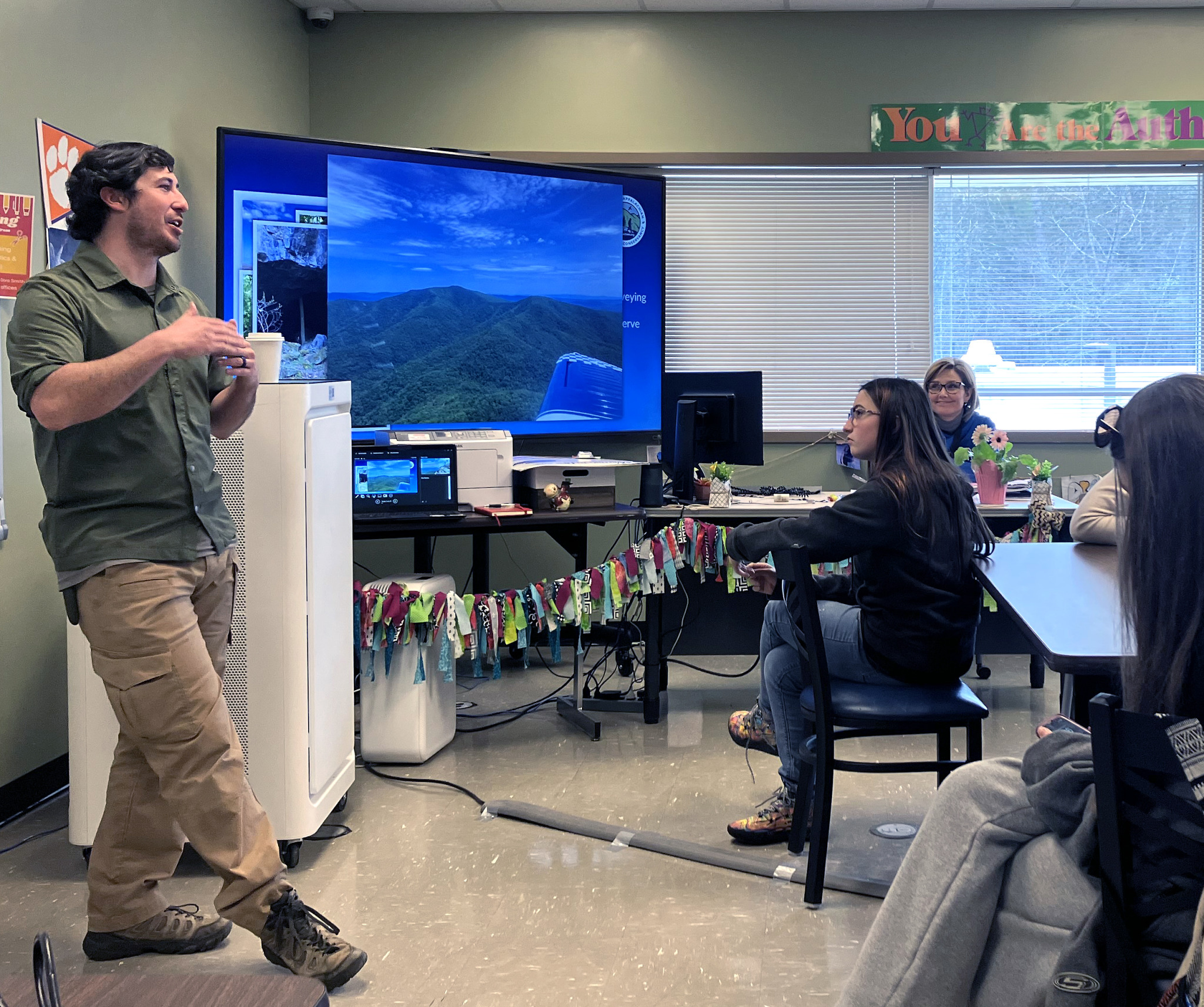 Park Greer at left stands to present to a class of seating students at Mayland Community College Early College High School, about careers in conservation.